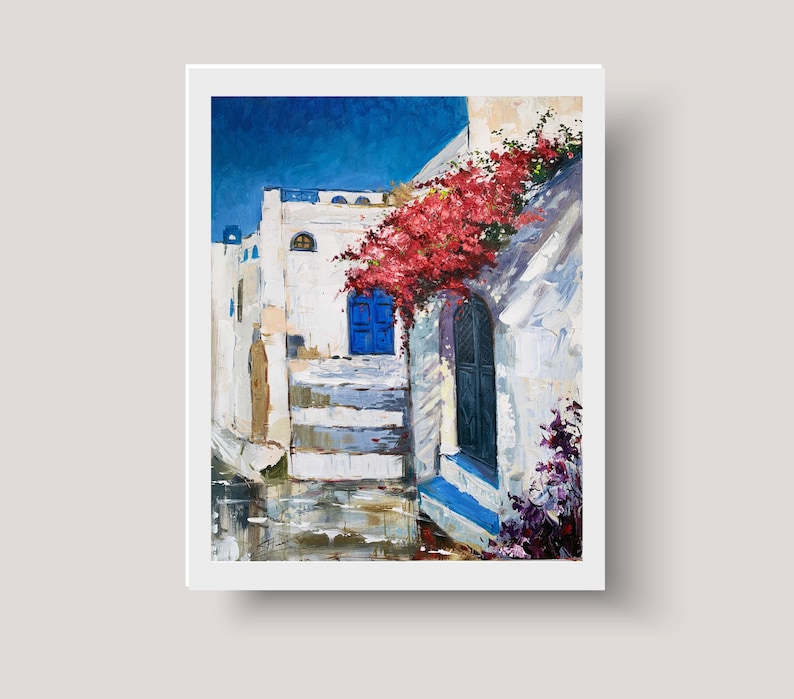 May include: A painting of a white building with a blue door and red flowers growing on the side. The building is in a narrow street with a blue sky in the background.