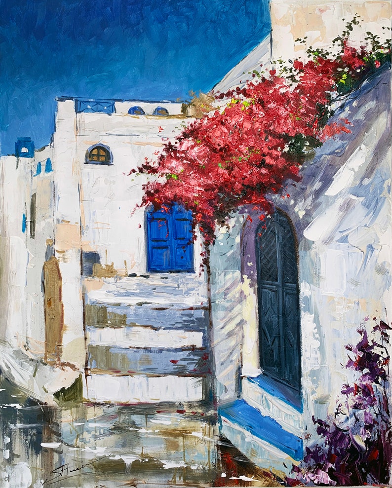 May include: A painting of a white building with a blue door and a red flower bush growing over it. The building is in a narrow alleyway with a blue sky in the background.