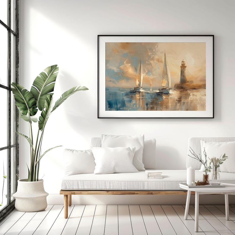 K&ouml;nnte beinhalten: Gerahmtes &Ouml;lgem&auml;lde mit zwei Segelbooten auf dem Wasser in der N&auml;he eines Leuchtturms. Das Kunstwerk verwendet Blau-, Creme- und Braunt&ouml;ne, wobei die wei&szlig;en Segel der Boote hervorgehoben werden. Das Gem&auml;lde h&auml;ngt &uuml;ber einem wei&szlig;en Sofa.