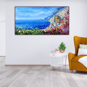 May include: A painting of a coastal scene with a golden-domed church, blue water, and a white sailboat in the distance. The scene is framed by lush green foliage and vibrant pink flowers.