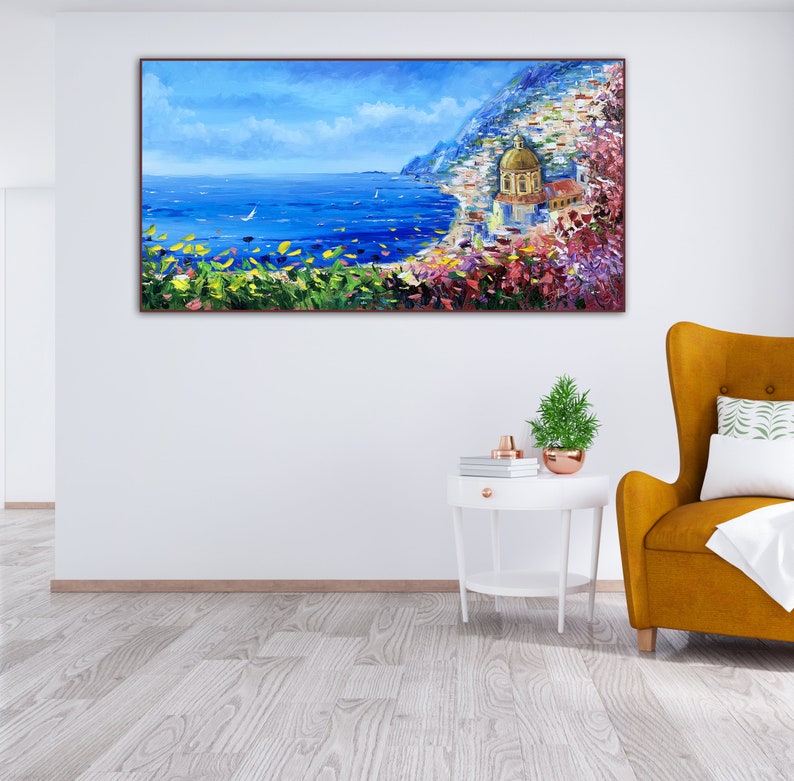May include: A painting of a coastal scene with a golden-domed church, blue water, and a white sailboat in the distance. The scene is framed by lush green foliage and vibrant pink flowers.