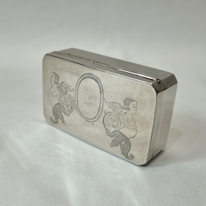 An 18th Century silver snuff box of Continental origin, engraved with opposing winged figures flanking a vacant cartouche, weighing 57g.