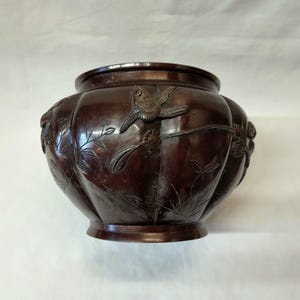 A good late 19th Century Japanese Meiji period bronze jardiniere / planter of 'melon' form with 8 lobes to the body decorated with birds.