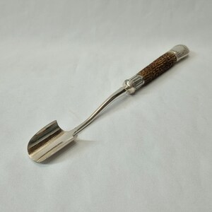 A lovely silver plated and sterling silver mounted Stilton cheese scoop with antler handle; a good quality item and a very tactile tool.