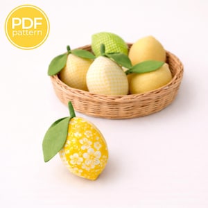 May include: A collection of fabric lemons in a woven basket, featuring various yellow and green patterns, including gingham, floral, and solid prints. Each lemon has a green fabric leaf attached to the top. A yellow circular badge reads PDF pattern.