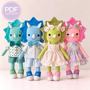 Può includere: Quattro bambole di peluche triceratopo con balze e corna in tessuto. Due bambole indossano camicie abbottonate con papillon e pantaloncini, due indossano vestiti con fiocchi. Le bambole sono verde acqua, blu, verde e rosa. Testo PDF pattern.
