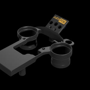 May include: A black plastic camera lens adapter with two lens holders and a small black and gold plate with the text "AIRFIX" on it.