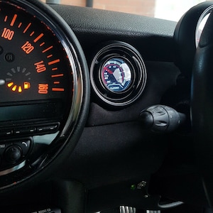 May include: A black dashboard with a red and white speedometer and a black gauge with a white face and the word "TURBO" printed on it.