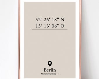 May include: A framed wall art print featuring a beige background with black text displaying the coordinates 52° 26' 18" N and 13° 13' 06" O, a black location pin icon, the word Berlin, and the address Matterhornstraße 46 in a rose gold frame.