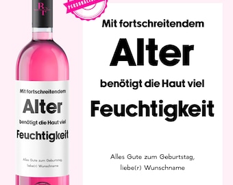 May include: A pink bottle of wine with a label that reads "Mit fortschreitendem Alter benötigt die Haut viel Feuchtigkeit" and "Alles Gute zum Geburtstag liebe(r) Wunschname".