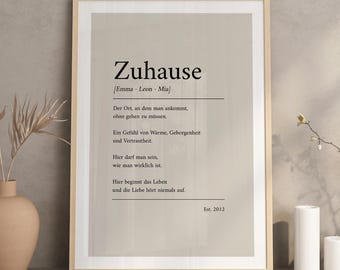 May include: A framed wall art print featuring the German word Zuhause in black text on a light beige background. The print includes a definition of the word, the names Emma, Leon, and Mia, and the text Est. 2012, all presented in a clean, minimalist layout.