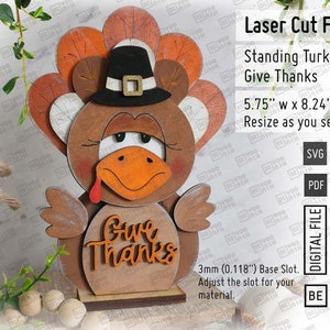 May include: Laser cut file for a standing turkey with a pilgrim hat and the words "Give Thanks". The turkey is brown with orange accents and is 5.75 inches wide by 8.24 inches tall. The file is available in SVG and PDF formats.