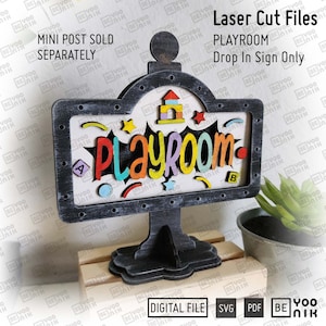 May include: A laser-cut wooden sign for a playroom, featuring the word "PLAYROOM" in colorful, 3D letters. The sign has a black frame and base, with decorative shapes and the text "Laser Cut Files".