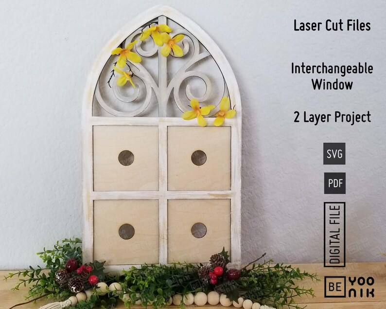 Op de afbeelding: Een wit houten raamkozijn met een decoratief ontwerp, met vier vierkante vakken. Het frame is versierd met gele bloemen. De tekst "Laser Cut Files", "Interchangeable Window", "2 Layer Project", "SVG", "PDF", "DIGITAL FILE", "BE", "YOO", en "NIK" is zichtbaar aan de rechterkant van de afbeelding.
