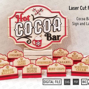 May include: Laser cut files for a hot cocoa bar sign and labels. The sign features the words "Hot Cocoa Bar" in a vintage style font with red and white accents. The labels are for different toppings, including peppermint, cinnamon, candy canes, sprinkles, caramel, mint chips, dark chocolate, milk chocolate, white chocolate, whipped cream, and marsh mallow.