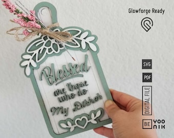 May include: A green and white wooden sign with the text "Blessed are those who do my dishes" in a decorative font. The sign has a heart shape at the bottom and a floral design at the top.