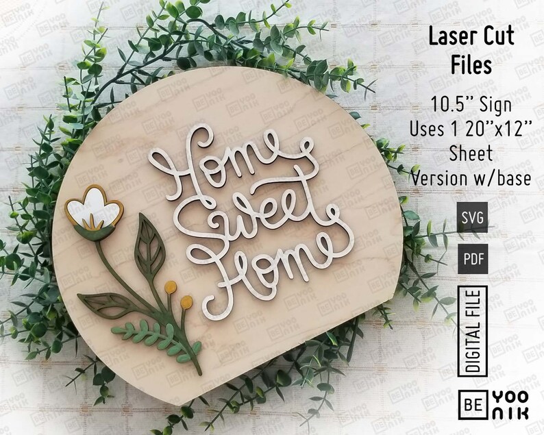 May include: A laser cut wooden sign with the text "Home Sweet Home" in a cursive font. The sign is shaped like a half circle and has a small floral design in the bottom left corner. The sign is 10.5 inches in diameter and uses a 20 inch by 12 inch sheet of wood.