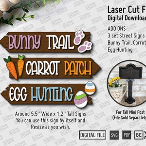 May include: Three wooden signs with a brown background and white text. The signs read "Bunny Trail", "Carrot Patch", and "Egg Hunting". The signs are decorated with carrots, bunny footprints, and Easter eggs. The signs are approximately 5.5 inches wide and 1.2 inches tall.