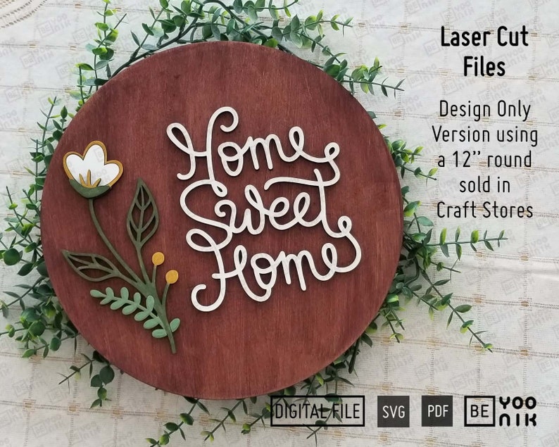 May include: A wooden round sign with the words "Home Sweet Home" in white script. The sign is decorated with a floral design featuring white flowers and green leaves.