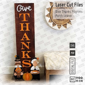 Può includere: Un cartello di legno con le parole "Give Thanks" in lettere arancioni. Il cartello è decorato con due figure di pellegrini, una zucca e un tacchino. Il cartello è un appoggio per il portico ed è disponibile come file digitale per il taglio laser.