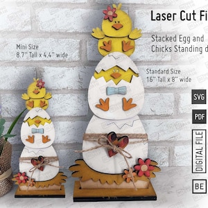 May include: Laser cut files for a stacked egg and chicks standing decor. The design features a yellow chick with a red bow on top of a white egg with a blue bow. The smaller version is 8.7 inches tall and 4.4 inches wide. The larger version is 16 inches tall and 8 inches wide.