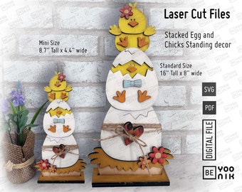 May include: Laser cut files for a stacked egg and chicks standing decor. The design features a yellow chick with a red bow on top of a white egg with a blue bow. The smaller version is 8.7 inches tall and 4.4 inches wide. The larger version is 16 inches tall and 8 inches wide.