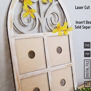 Op de afbeelding: Witte houten wanddecoratie met een decoratief gebogen raamkozijn en vier vierkante vakken. Het raamkozijn heeft een bloemmotief met gele bloemen. De tekst "Laser Cut Files" en "Insert Designs Sold Separately" is zichtbaar in de afbeelding. De tekst "SVG" en "PDF" is ook zichtbaar in de afbeelding.