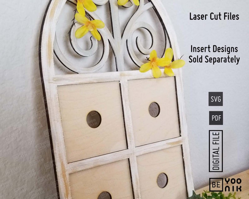 Op de afbeelding: Witte houten wanddecoratie met een decoratief gebogen raamkozijn en vier vierkante vakken. Het raamkozijn heeft een bloemmotief met gele bloemen. De tekst "Laser Cut Files" en "Insert Designs Sold Separately" is zichtbaar in de afbeelding. De tekst "SVG" en "PDF" is ook zichtbaar in de afbeelding.