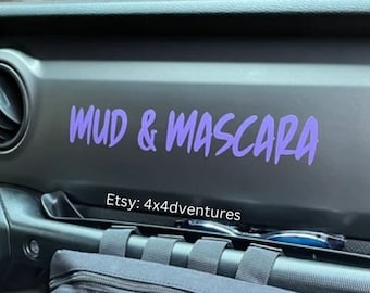 May include: A black Jeep Wrangler interior with a purple vinyl decal that reads "MUD & MASCARA" and a black zippered pouch attached to the passenger side grab handle. The text "Etsy: 4x4adventures" is printed below the decal.