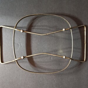 Puede incluir: Un estante de alambre de metal plateado con cuatro pomos redondos. El estante est&aacute; dise&ntilde;ado para sostener un plato de vidrio o cer&aacute;mica.