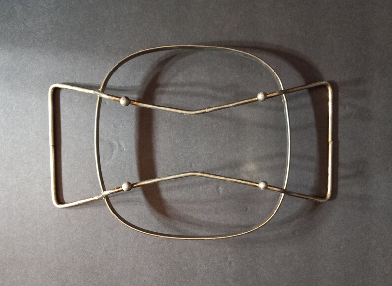 Puede incluir: Un estante de alambre de metal plateado con cuatro pomos redondos. El estante est&aacute; dise&ntilde;ado para sostener un plato de vidrio o cer&aacute;mica.