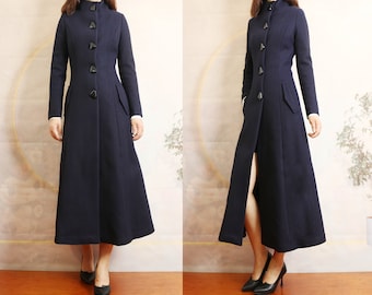 May include: A long, navy blue coat with a high collar and a row of buttons down the front. The coat has a fitted waist and a flared skirt.