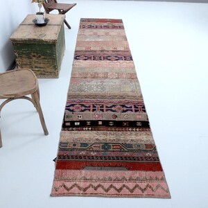 Peut inclure: Un tapis long et étroit avec un motif géométrique coloré. Le tapis est fait de tissu tissé et présente une variété de couleurs, notamment le rose, le rouge, le bleu et le vert. Le tapis est parfait pour ajouter une touche de couleur et de style à n'importe quelle pièce.