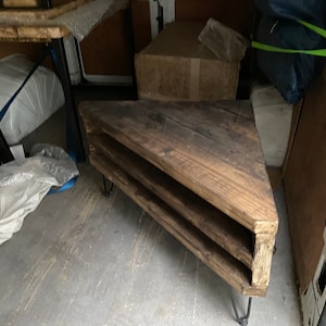 K&ouml;nnte beinhalten: Ein rustikales, dreieckiges Holzregal mit drei Ebenen. Es hat Haarnadelbeine und eine dunkle Holzbeize. Das Design ist abgewinkelt, und die Holzmaserung ist sichtbar. Das Regal dient wahrscheinlich zur Pr&auml;sentation oder Aufbewahrung.