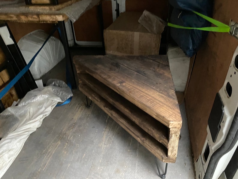 K&ouml;nnte beinhalten: Ein rustikales, dreieckiges Holzregal mit drei Ebenen. Es hat Haarnadelbeine und eine dunkle Holzbeize. Das Design ist abgewinkelt, und die Holzmaserung ist sichtbar. Das Regal dient wahrscheinlich zur Pr&auml;sentation oder Aufbewahrung.