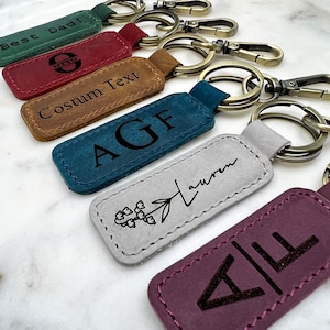 a group of four keychains with different designs on them