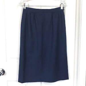 Puede incluir: Una falda midi azul oscuro de silueta recta y diseño sencillo.
