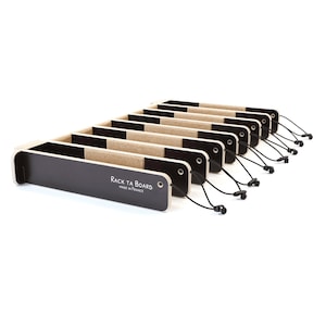May include: Set of eight black and beige wooden practice pads with a black string attached to each. The pads are labeled "Rack Ta Board Made in France".