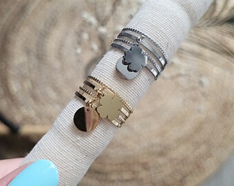 Multi-row adjustable stainless steel ring with clover charm and pellet.