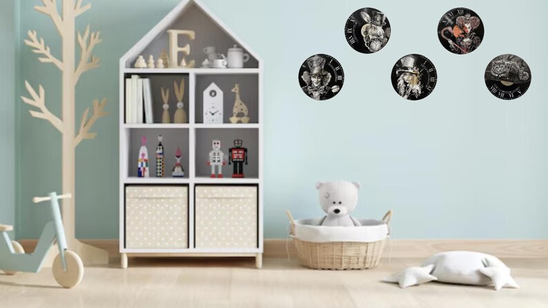 K&ouml;nnte beinhalten: Ein Kinderzimmer mit einem wei&szlig;en B&uuml;cherregal, Spielzeug und f&uuml;nf runden Uhren mit Alice im Wunderland-Charakteren. Ein hellblauer Roller und eine Baumdekoration aus Holz befinden sich links. Ein wei&szlig;er Teddyb&auml;r sitzt in einem Weidenkorb.