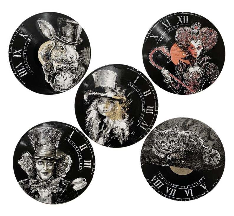 K&ouml;nnte beinhalten: F&uuml;nf runde Wanduhren aus schwarzen Schallplatten, jede mit handgemalten Illustrationen von Figuren, darunter ein Kaninchen mit Taschenuhr, eine K&ouml;nigin mit Flamingo, eine Person mit Zylinder, ein Hutmacher und eine Katze.
