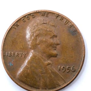 Op de afbeelding: Een koperkleurige Lincoln penny uit 1956. De voorzijde toont een profiel van Abraham Lincoln, het woord "LIBERTY" en de inscriptie "IN GOD WE TRUST". Het jaartal "1956" is zichtbaar.