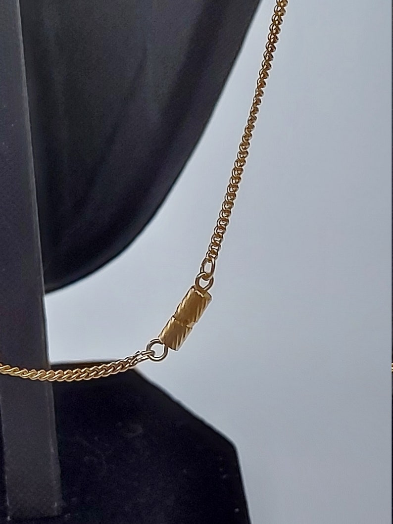 May include: A gold chain necklace with a magnetic clasp. The chain is made of small, linked circles.
