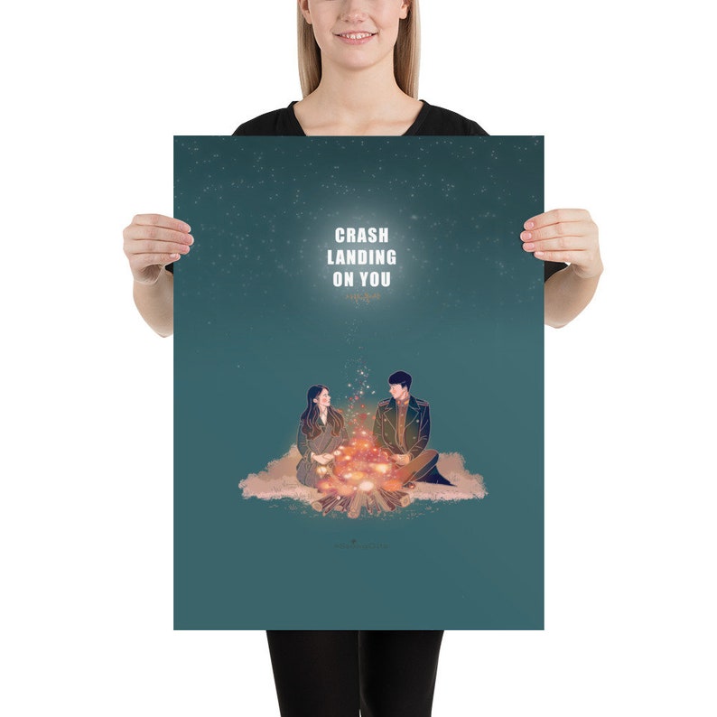 May include: A teal blue poster with a starry night sky background. The poster features a couple sitting by a campfire with the text "Crash Landing On You" in white.