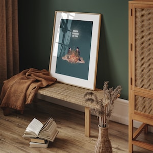 May include: A framed poster with a blue background and a couple sitting by a campfire. The text "Crash Landing On You" is written in white letters on the poster.