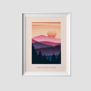Op de afbeelding: Een digitale illustratie van een bergketen met een grote zon die erachter ondergaat. De bergen zijn in een verloop van roze, paars en blauw. De zon is fel oranje. De tekst "DAW ETO HAUL AR FRYN" staat onderaan de afbeelding.