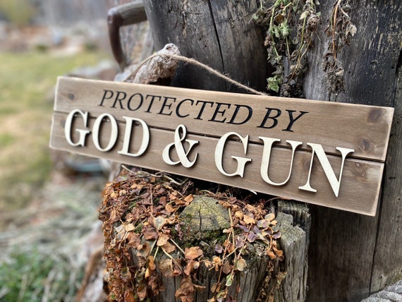 Laser engraved sign for a man cave or to just display proudly. Protected by God and gun sign for door or entryway. Great gift idea.