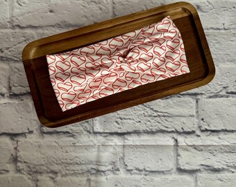 May include: White headband with a red baseball pattern. The headband is tied in a knot.