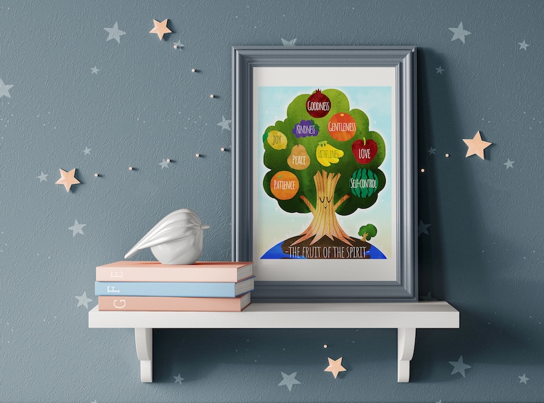 May include: A framed print of a tree with colorful fruit, each labeled with a virtue like "Joy" and "Love." The text "The Fruit of the Spirit" is at the bottom. The print sits on a white shelf with books and a bird figurine, against a blue wall with star decorations.