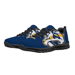 May include: A pair of blue and gold athletic shoes with a graphic of a mascot on the side. The shoes have black laces and a white sole.